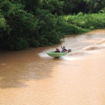 Locals on small boat greet superyacht crew on the Kinabatangan River