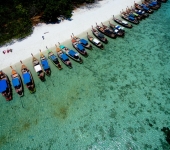 Longtail boats waiting at Koh Rawi to take guests back to Koh Lipe 